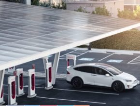 auto elektromobil Tesla Model X se nabíjí u nabíjecí stanice Tesla Supercharger doplněné o solární střešní elektrárnu